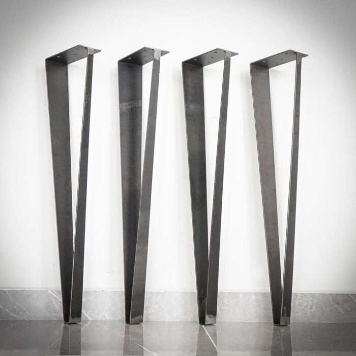 Arch-104.jpg Fyra svarta stålbordsben mot vit vägg.