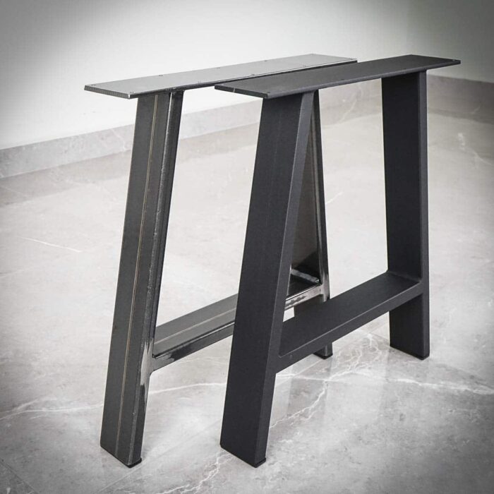 Bankben-A7 Svarta metallbordsben på grått golv.