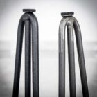 Två böjda metallben med filtskydd