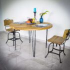 Runt träbord med två stolar och dukning.