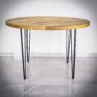 Runt bord med metallben på marmorgolv.