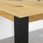 Hörn av träbord med metallben.