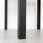 Svart metallbordsben på betonggolv