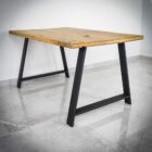 Träbord med metallben på klinkergolv