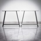 Två moderna bordsben på marmorgolv.