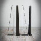 Fyra svarta metallbordben på trägolv