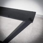 Svart metallbord underifrån på grått golv.