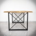 Träbord med metallben på klinkergolv.