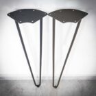 Två svarta bordben mot vit vägg