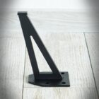 Svart metallhyllkonsol på trägolv