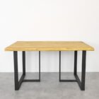 Träbord med metallben på grått golv.