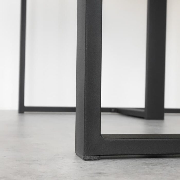 Bordsben-Kvadro-T-6.jpg Modern svart bordsben av metall på grått golv.
