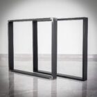 Svarta metallbordssben på grå golvytan