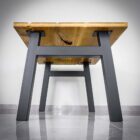 Svart metallbord med träskiva, fotograferat från sidan.