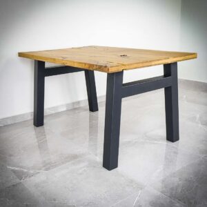 Träbord med metallben på stengolv.