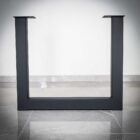 Svart metallbordben på grått golv.