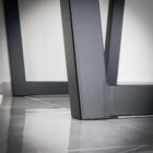 Svart metallbordben på glansigt golv