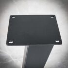 Svart metallbordben med hål i hörnen.