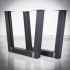 Svarta stålbordben på marmorgolv.