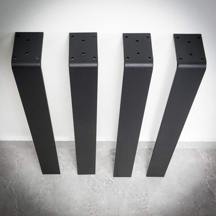 Bordsben-Platt-4-1.jpg Fyra svarta bordsben mot en vägg.