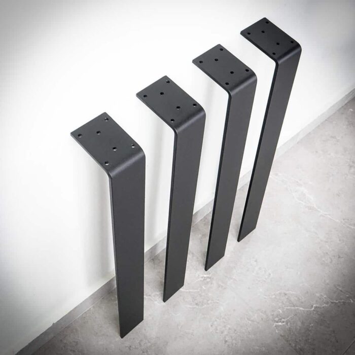 Bordsben-Platt-6-1.jpg Fyra svarta bordsben mot en vägg.