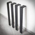 Fyra svarta möbelben mot vit vägg.