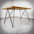 Modernt bord med metallben på klinkergolv.