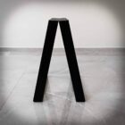 Svart, V-format föremål på grått golv.