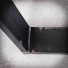 Svetsad metallfog på grått golv.