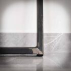 Närbild av ett metallbordben på marmorgolv.