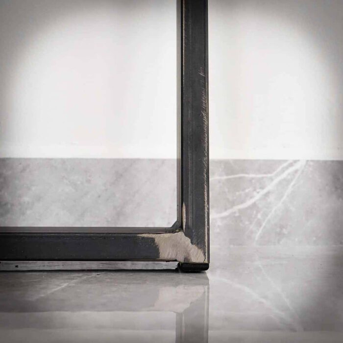 Bordsben-TILT-4 Närbild av ett metallbordben på marmorgolv.