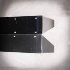 Två svarta metallhyllor med hål för skruvar.