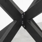 Svart metallkors på bordet undersida.