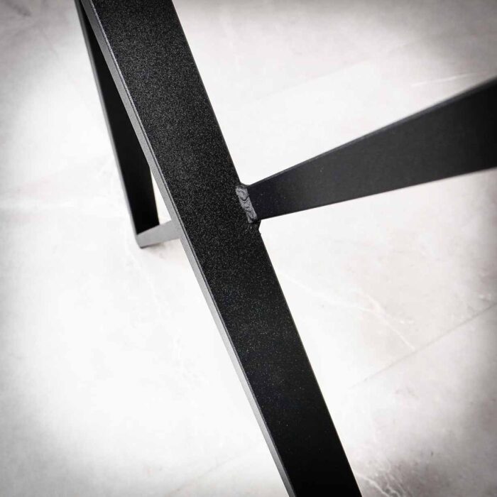 Bordsben-VIVA-16.jpg Svart metalliskt X-format bordsben på golv.