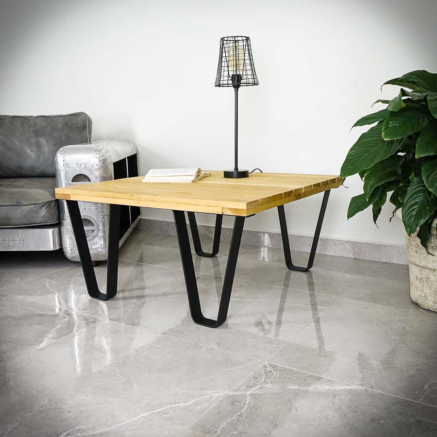 Soffbord med lampa och bok i vardagsrum.