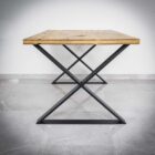 Rustikt bord med metallben på kakelgolv.