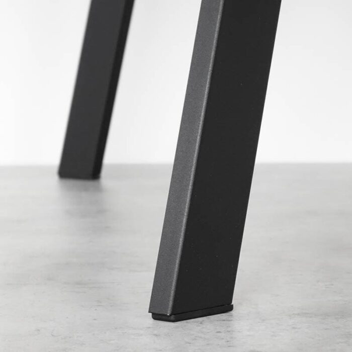 Bordsben-Y-Metall-Svart-1.jpg Närbild av stolben på golv.