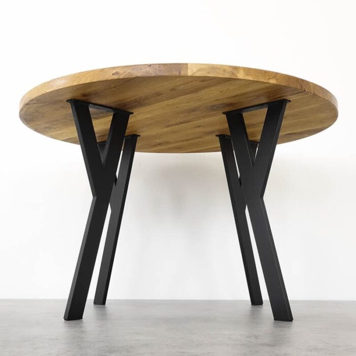 Bordsben-Y-Metall-Svart-5.jpg Runt träbord med metallben på grått golv.