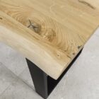 Träbord med metallben på kakelgolv.