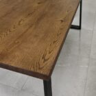 Träbord med metallben på klinkergolv.