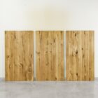 Tre träbordsskivor lutade mot väggen.