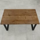 Träbord med svarta ben på grått golv.