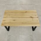 Träbord med svarta ben på klinkergolv.