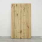 Träbordsskiva med fjärilsskarvar mot vit vägg.