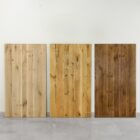 Tre träpaneler i olika färger mot vägg.