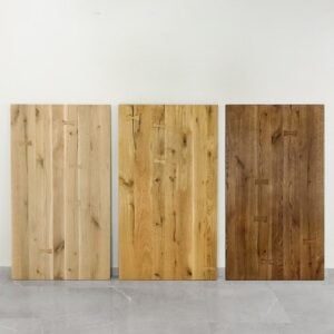 Tre träpaneler i olika färger mot vägg.