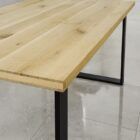 Ekträbord med svarta metallben på klinkergolv.