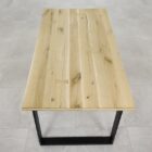 Rektangulärt träbord med metallben på golv