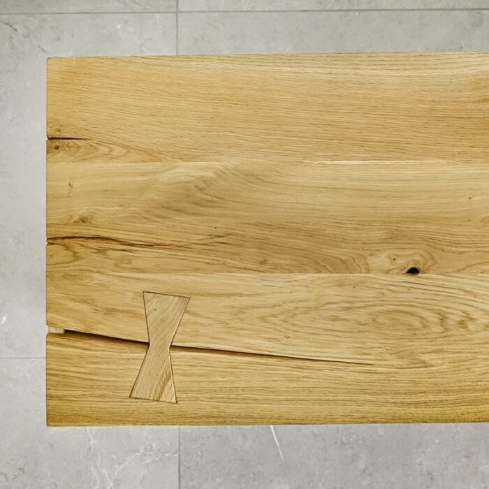 Bordsskiva-Antique-2-Grundoljad-3.jpg Träbord med fjärilsförband mot grått golv.