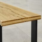 Träbord med metallben på stenbeläggning.